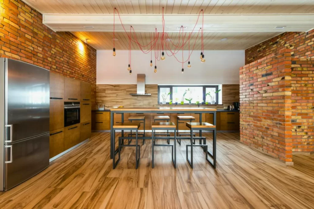 Modern industrial kitchen remodeling with exposed brick walls, sleek stainless steel appliances, and unique pendant lighting – ideal for stylish home kitchen design.