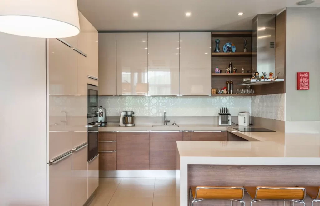 Modern kitchen remodeling featuring sleek cabinets, a minimalist breakfast bar with stools, and integrated appliances for a clean and functional design.
