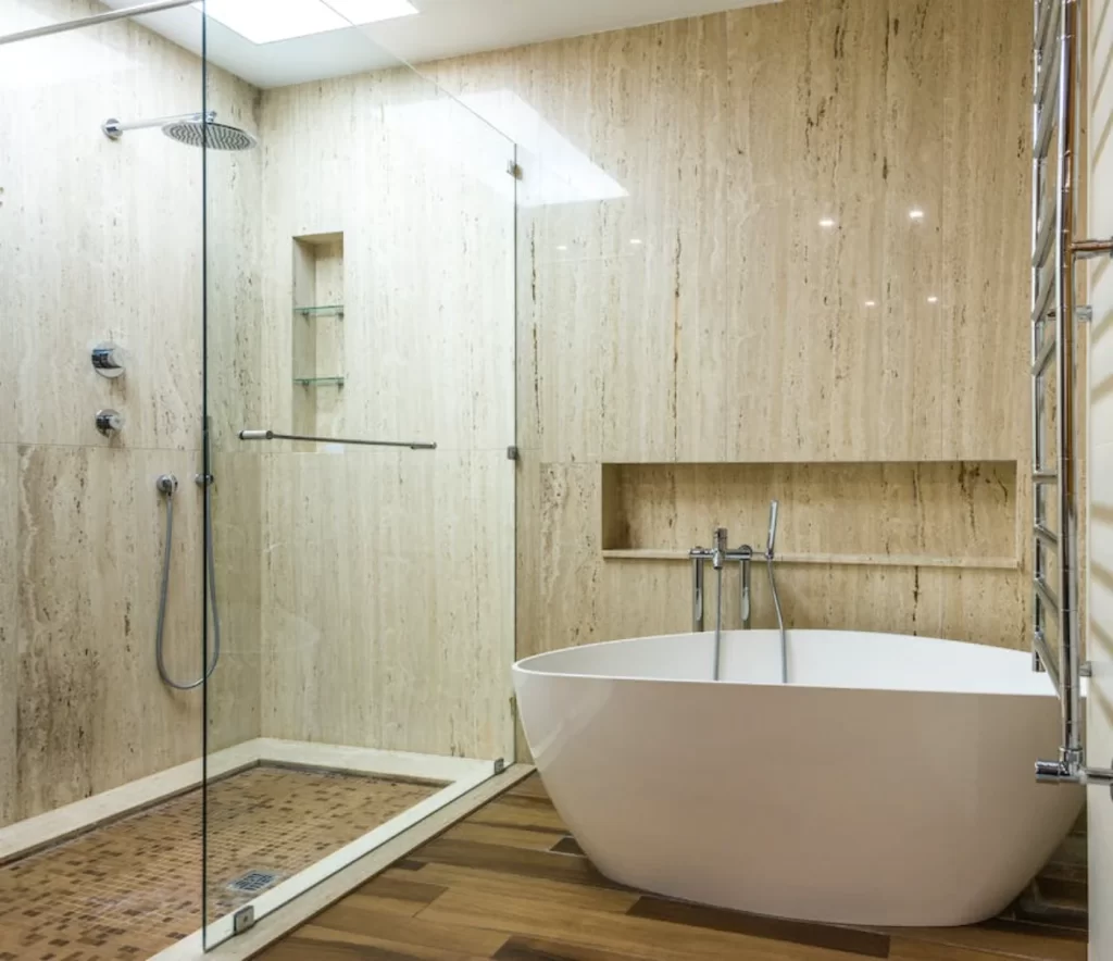 Luxury bathroom remodeling with freestanding tub, glass shower enclosure, natural stone walls, and wooden flooring for a spa-like ambiance.